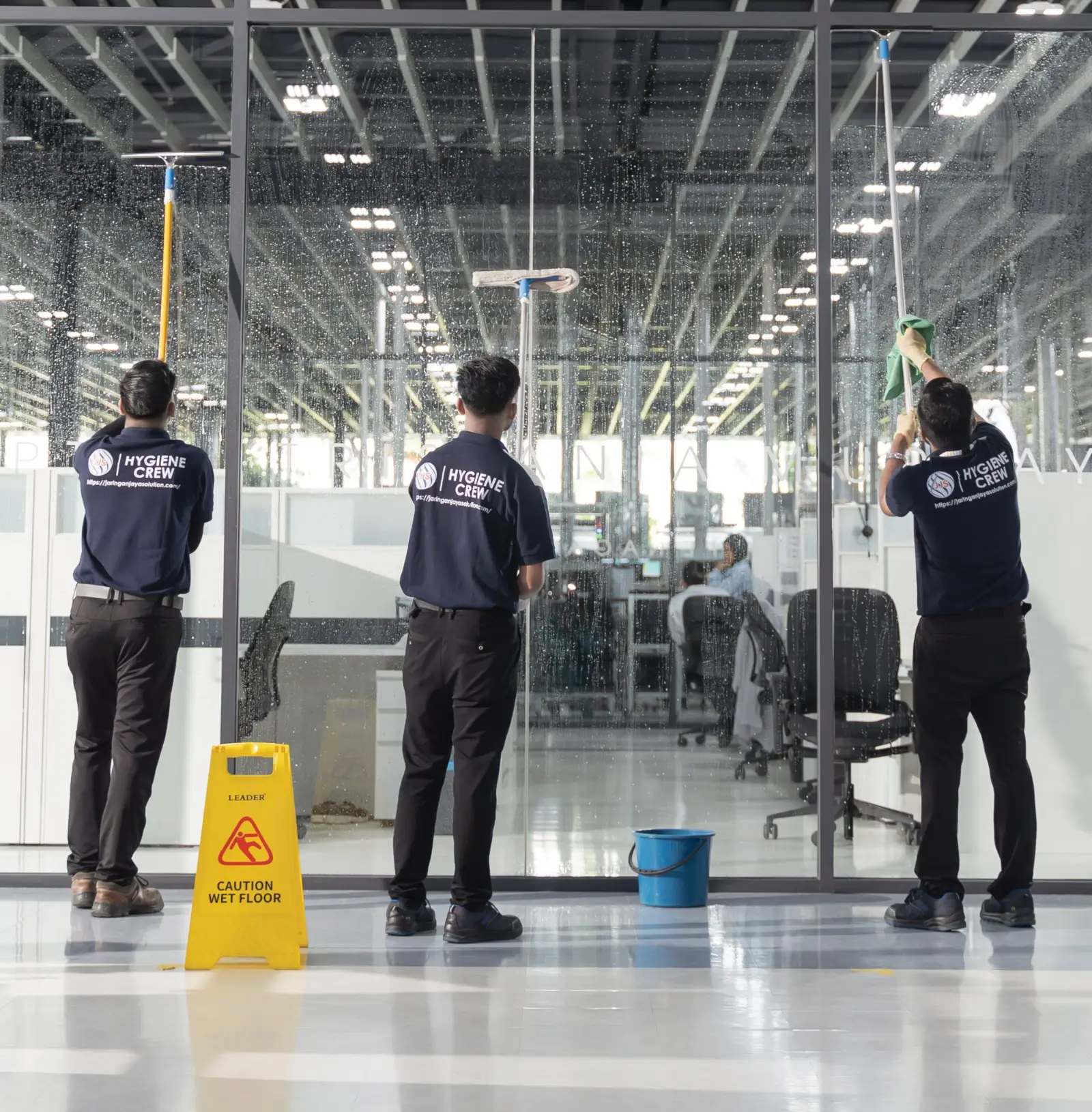 Jaringan Jaya hygiene crew cleaning full-height office glass